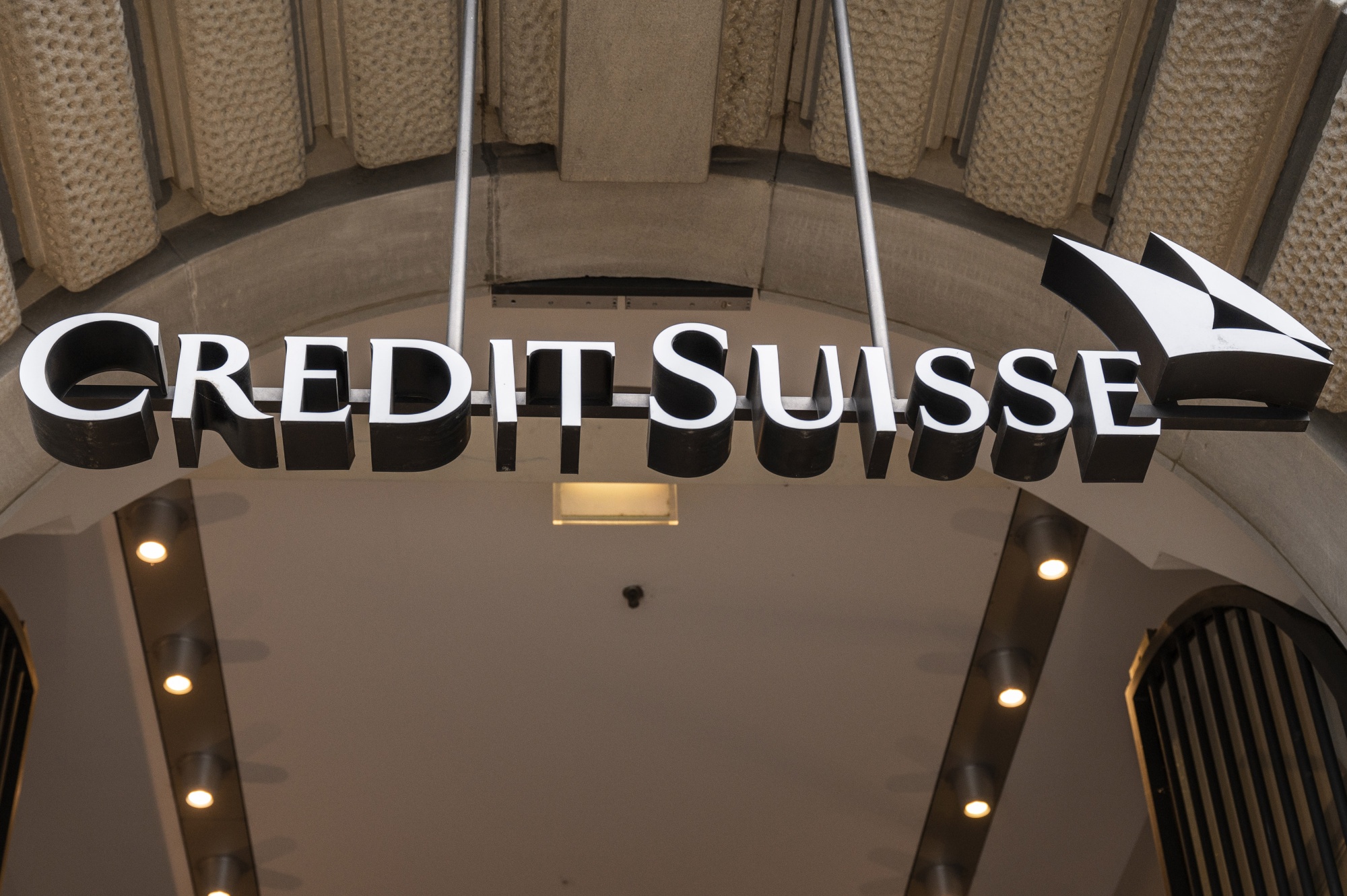 Signage hangs over the entrance of a Credit Suisse Group AG branch in Zurich, Switzerland. Concerns about the Swiss giant are among signs of trouble emerging around the world that have investors betting&nbsp;central bank hawkishness is about to peak.