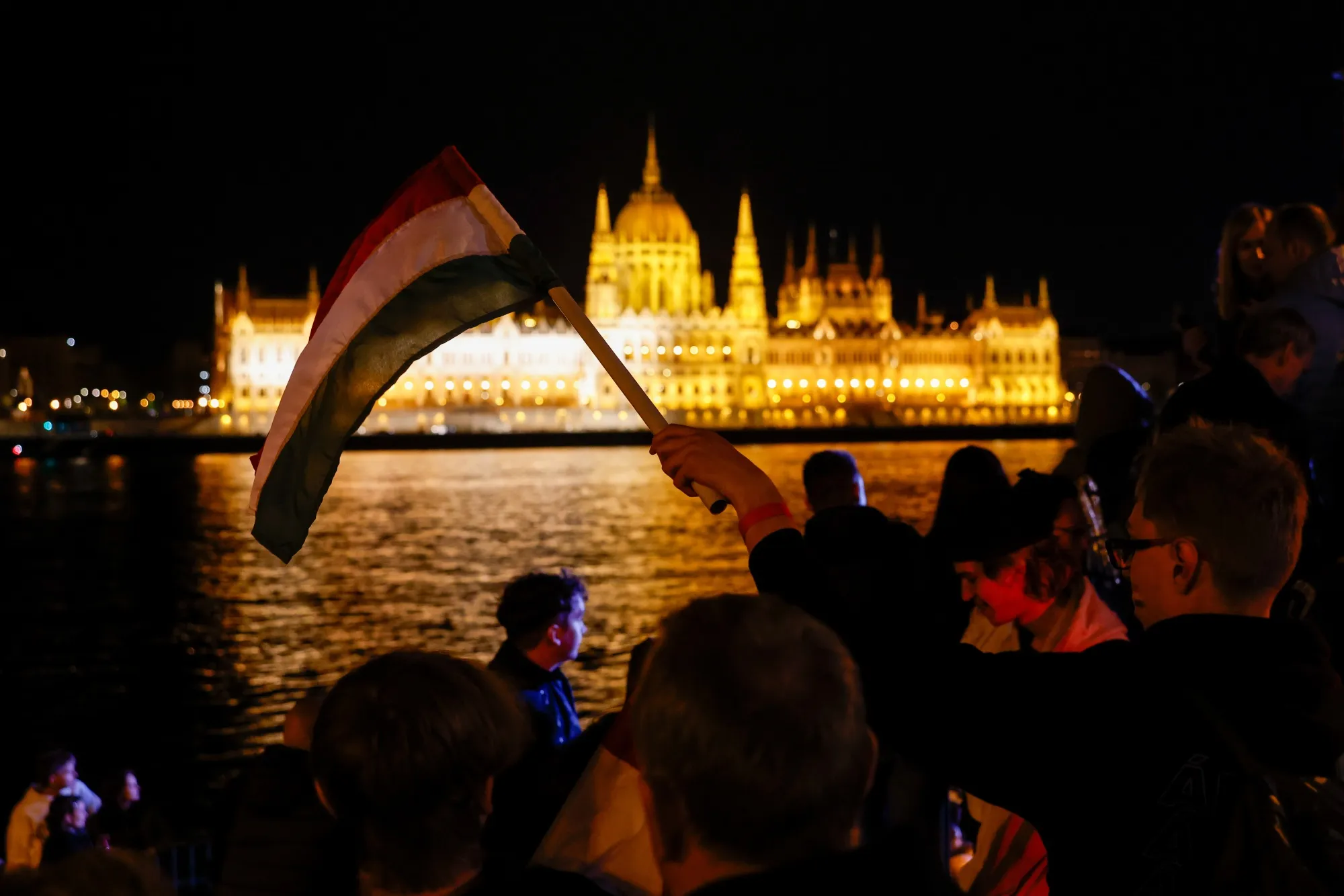 A supporter holds a&nbsp;Hungarian flag during Peter Magyar’s Tisza party&nbsp;election event across from parliament in Budapest.