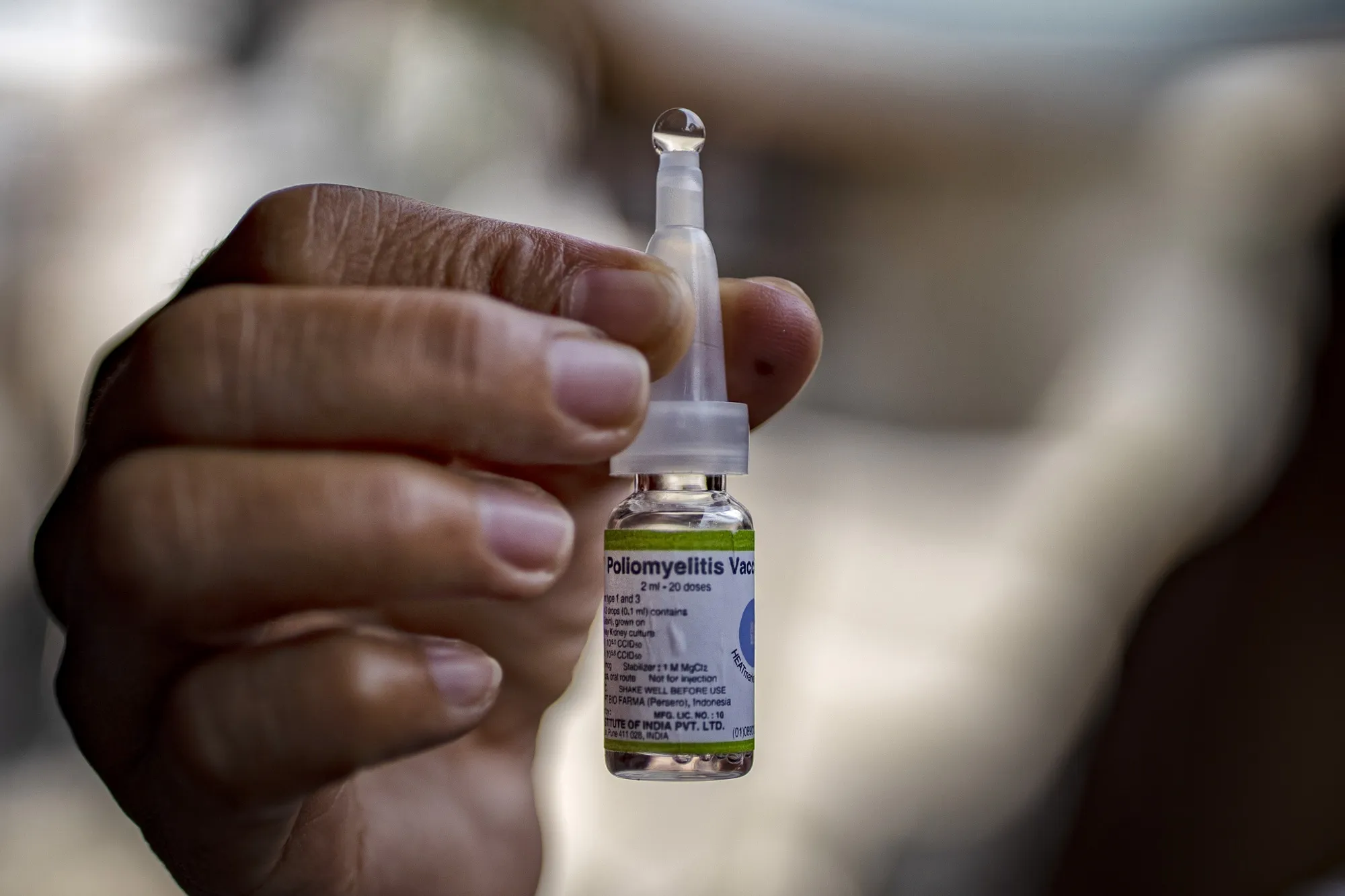 A community health worker shows a vial of an oral polio vaccine in Manila, Philippines.&nbsp;