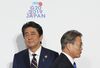Moon Jae-in, South Korea's president, right, walks past Shinzo Abe, Japan's prime minister.