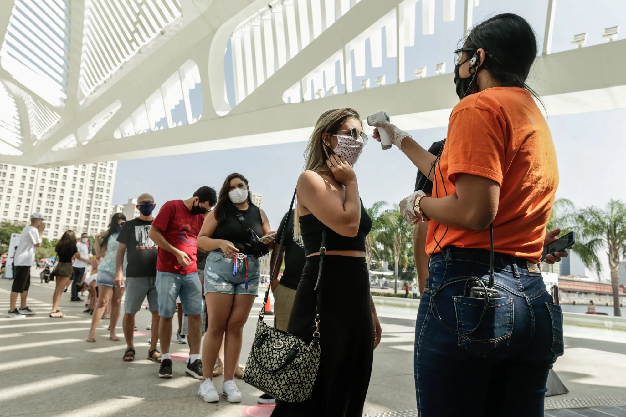 Visitors have their temperatures taken outside of the Museum of Tomorrow, during its reopening in Rio de Janeiro, Brazil, on Sept. 5. Rio continues reopening economy, even as cases rise.