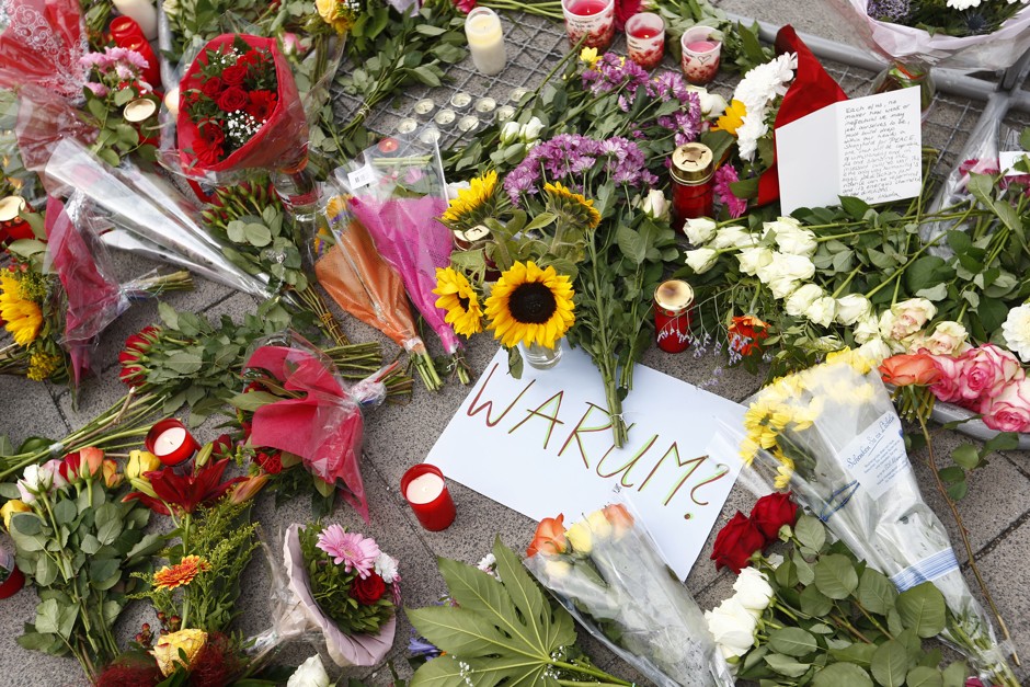 &quot;Why?&quot; asks a placard laid among tributes outside Munich Olympia shopping mall.