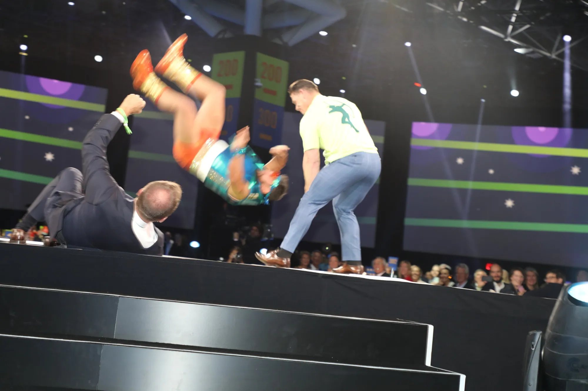 John Cena body slams the Impoverisher, who’d brought Paul Tudor Jones to the ground.