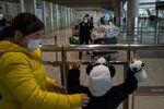 A boy dressed in a panda costume greets a relative at Beijing airport.