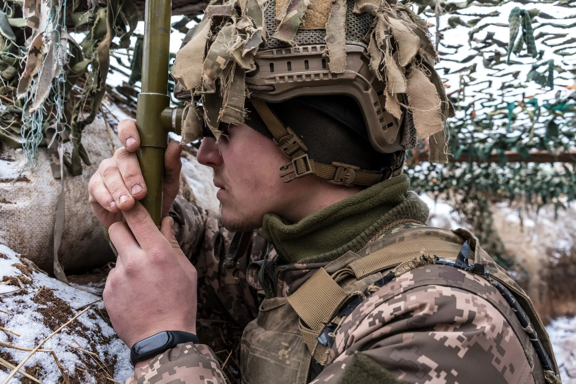 A&nbsp;Ukrainian soldier uses a hand-held periscope to view the positions of Russian-backed troops&nbsp;on Jan.&nbsp;17.