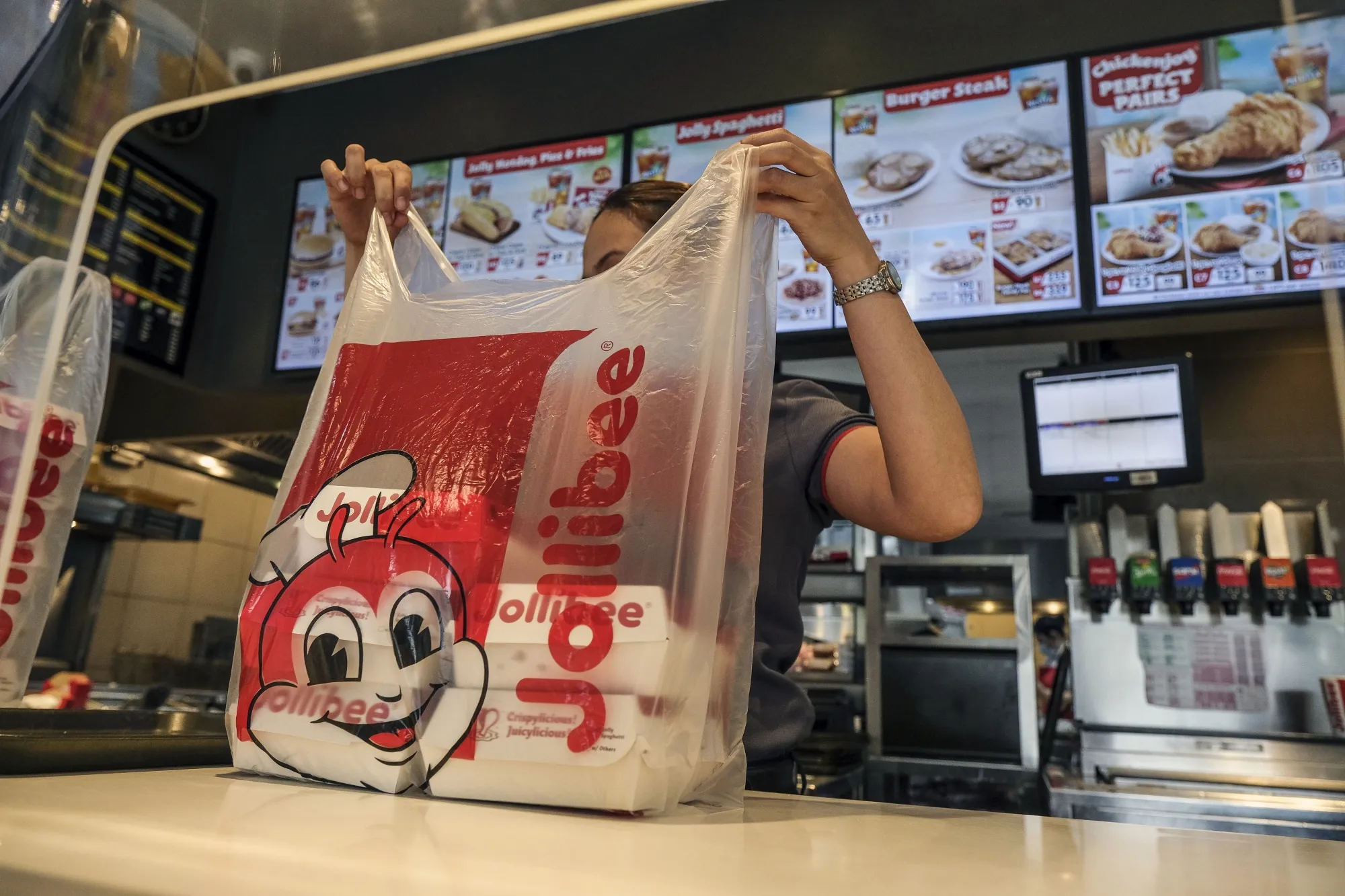 A service assistant prepares an order at the Jollibee Foods Corp. restaurant in Taguig City, Manila.&nbsp;