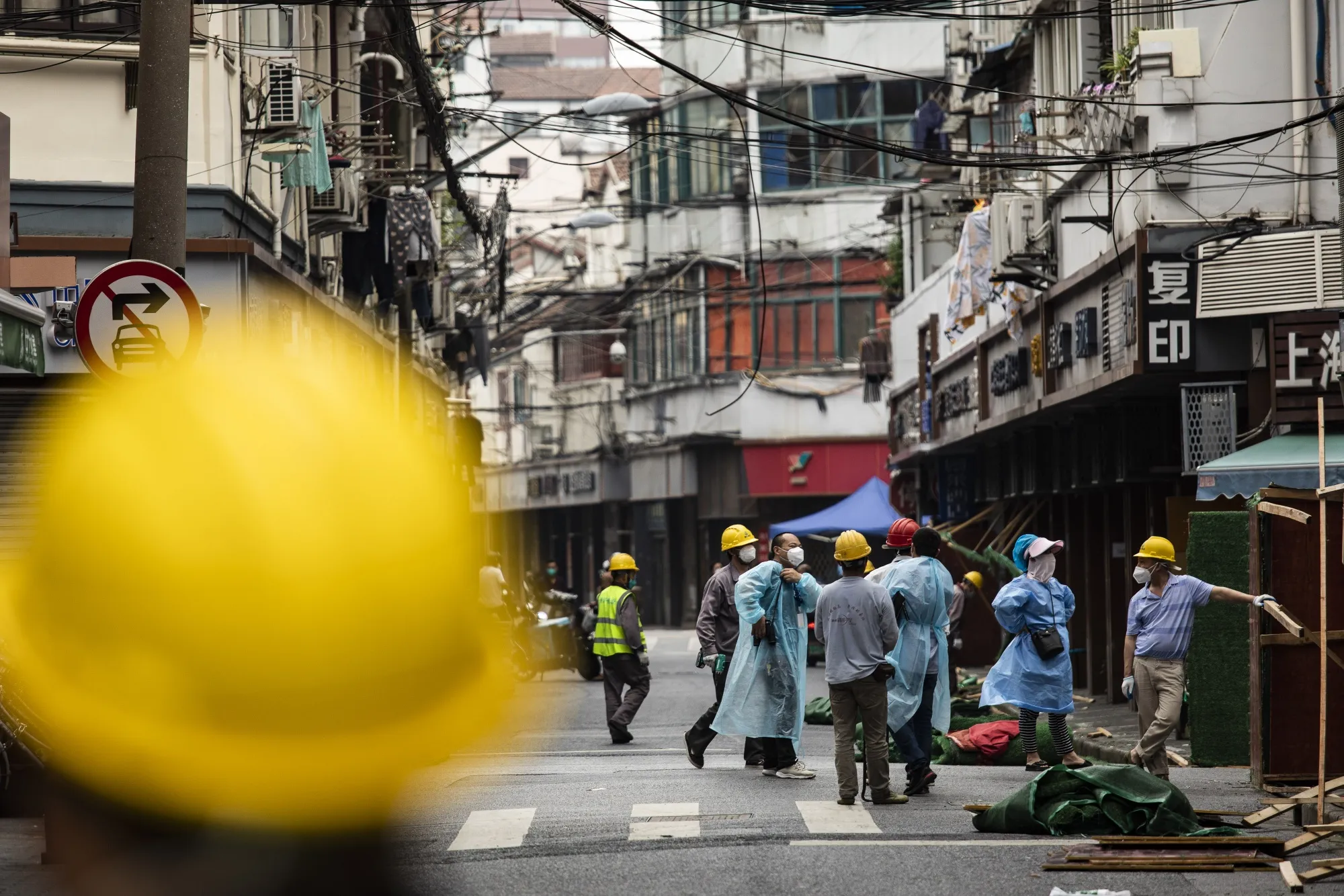 Workers remove barriers previously surrounding a neighborhood placed under lockdown in Shanghai.