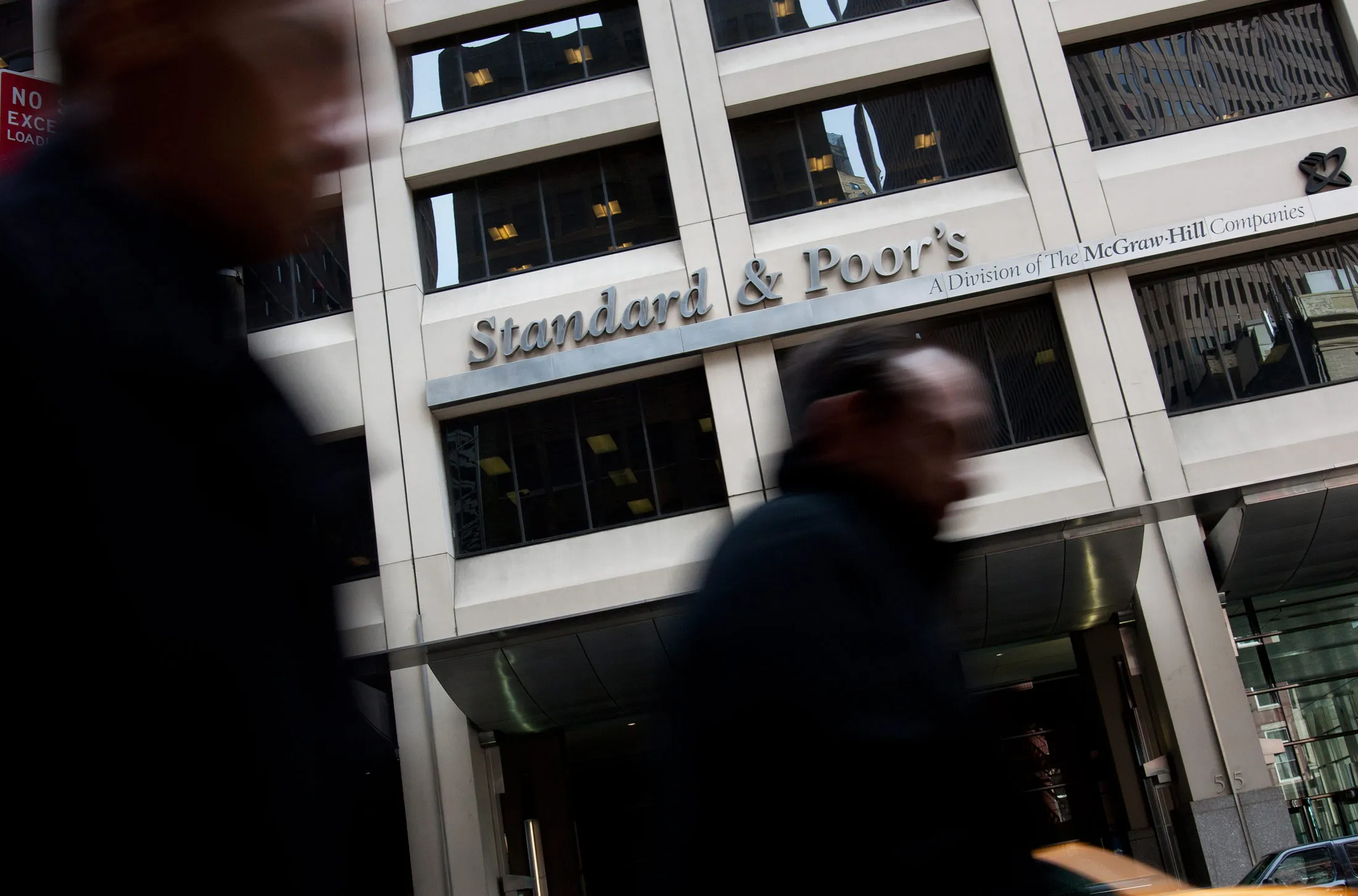 Pedestrians walk past the Standard &amp; Poor's offices in New York.
