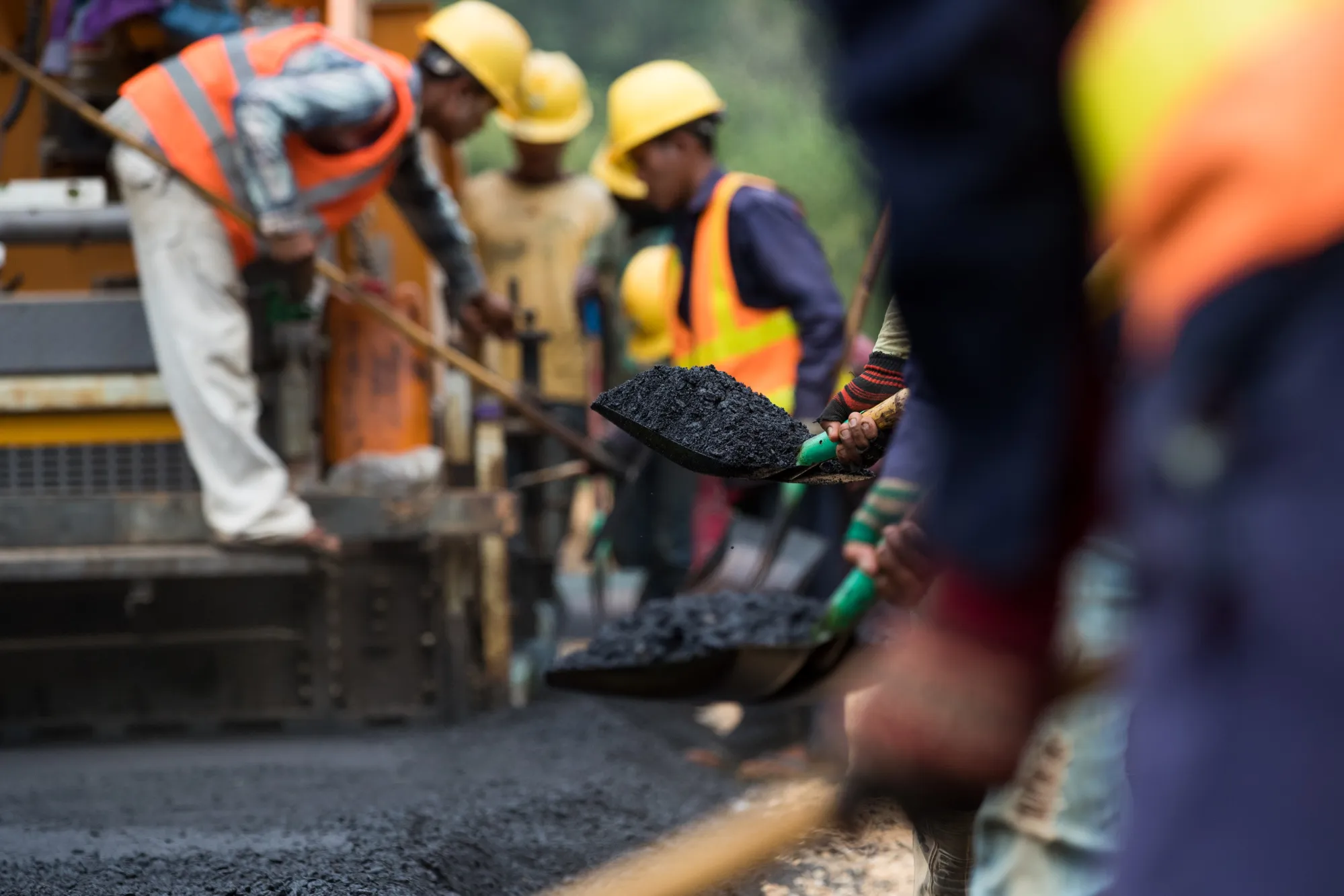 Workers use shovels to pave a highway under construction on the outskirts of Dawei, Myanmar, on&nbsp;Dec. 22, 2017.&nbsp;
