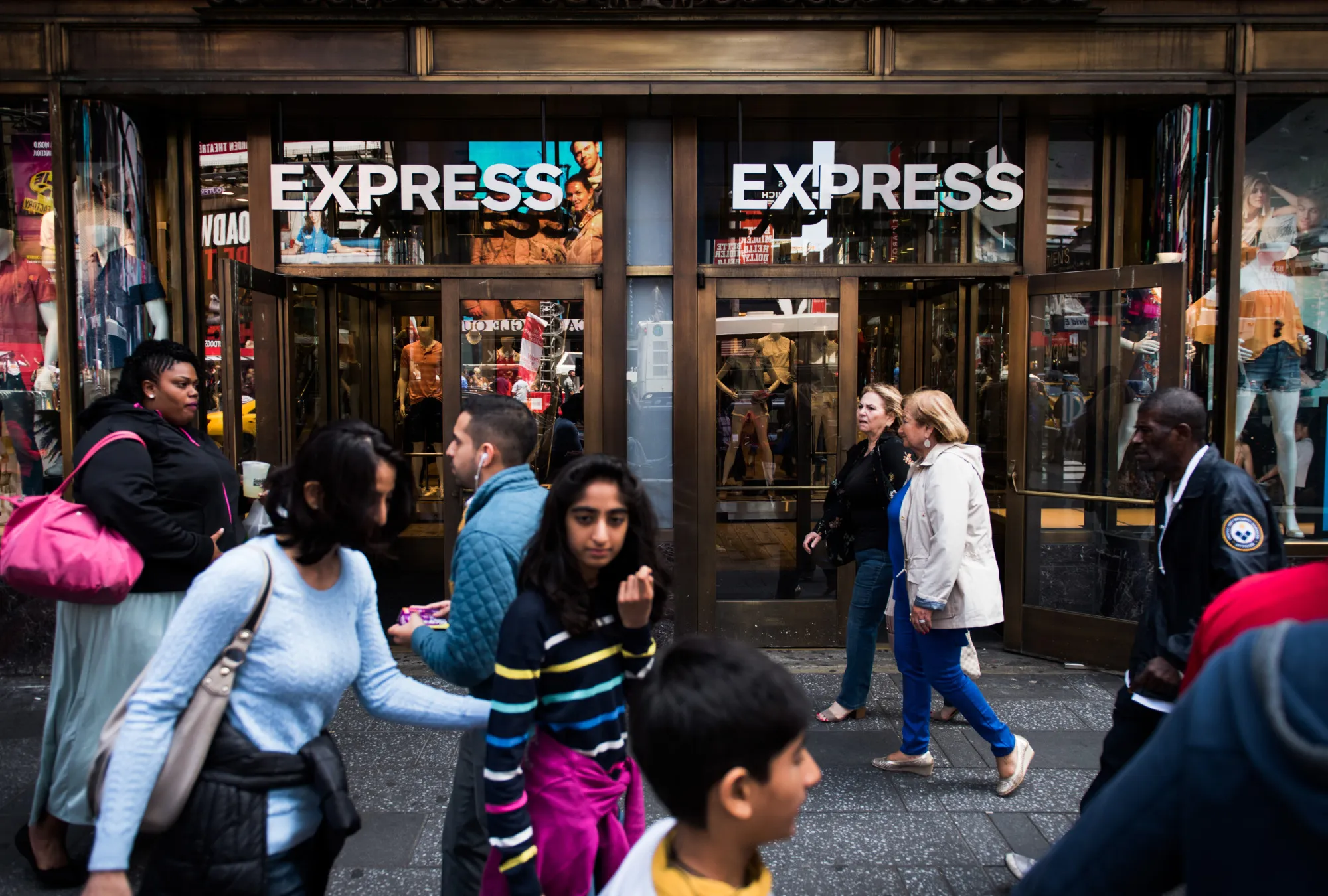 Pedestrians walk past an Express Inc. store in New York, U.S., on Wednesday, May 31, 2017.