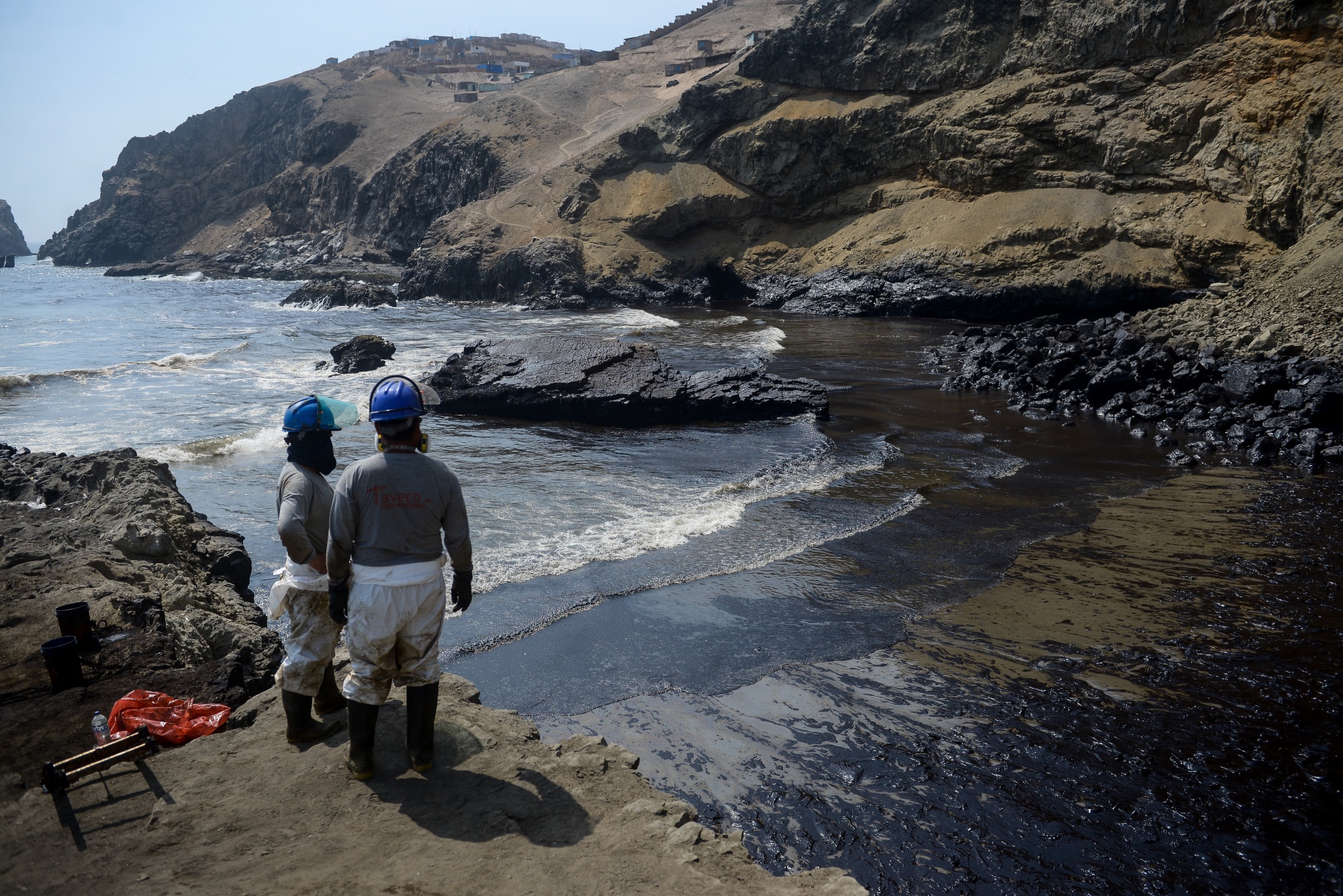 Workers observe an oil spill on Cavero beach in&nbsp;Peru, on Jan. 19, 2022.&nbsp;