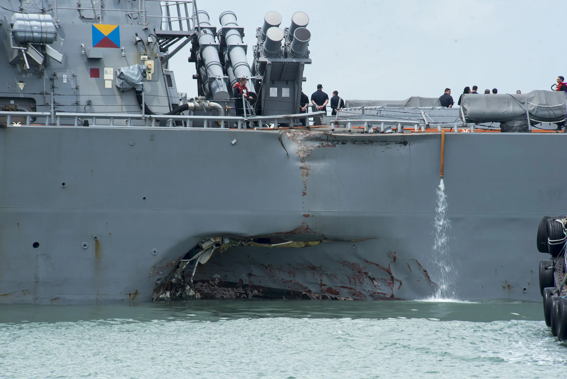 Damage to the portside is visible as the Guided-missile destroyer USS John S. McCain (DDG 56) steers towards Changi Naval Base, Republic of Singapore, following a collision with the merchant vessel Alnic MC while underway east of the Straits of Malacca and Singapore on Aug. 21.
