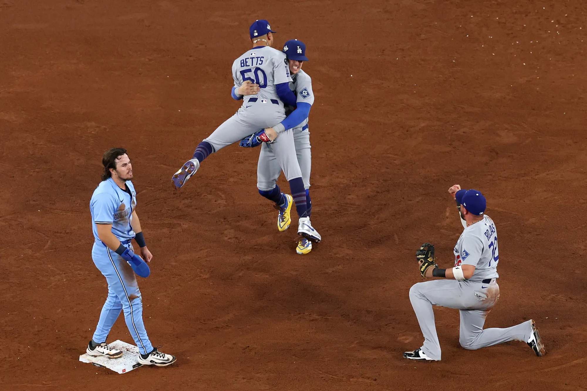 Los Angeles Dodgers players celebrate after forcing out Toronto Blue Jays' Addison Barger on the second base for the final out of game six of the World Series.