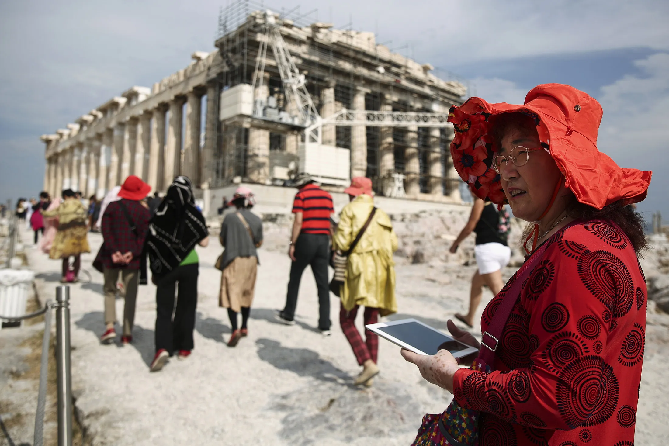 A Chinese tourist carries a tablet device during a visit to the Parthenon temple in Athens.
