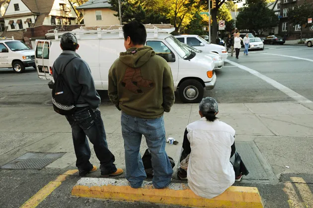 Immigrant men wait to find work in the early morning on a street corner in the Brooklyn, NY

