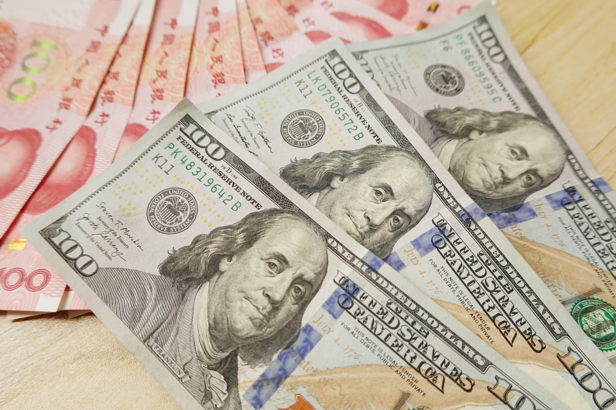 In this photo illustration, 100 US dollar notes and 100 RMB