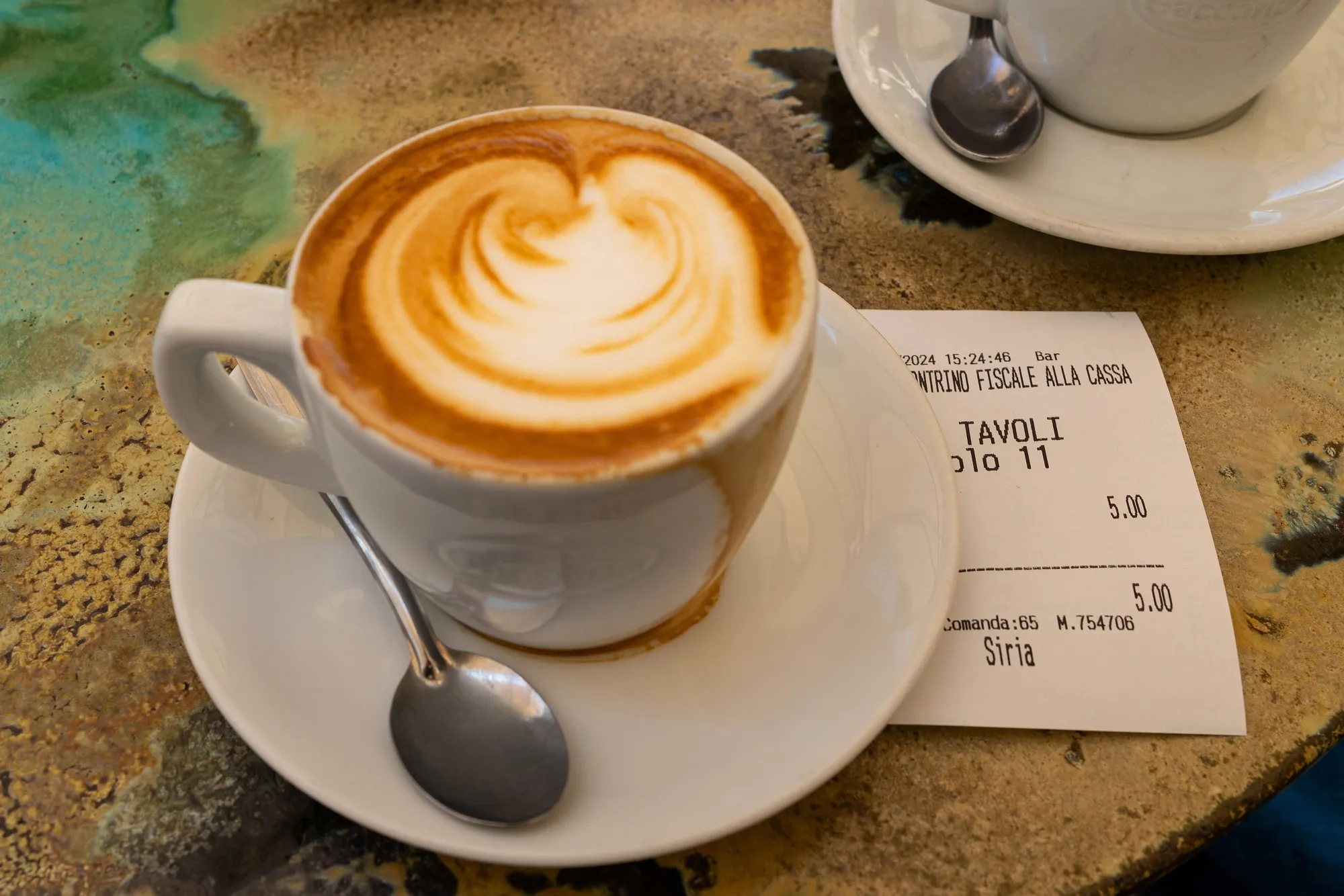 A cafe receipt beside a coffee in the old town in Assisi, Italy.