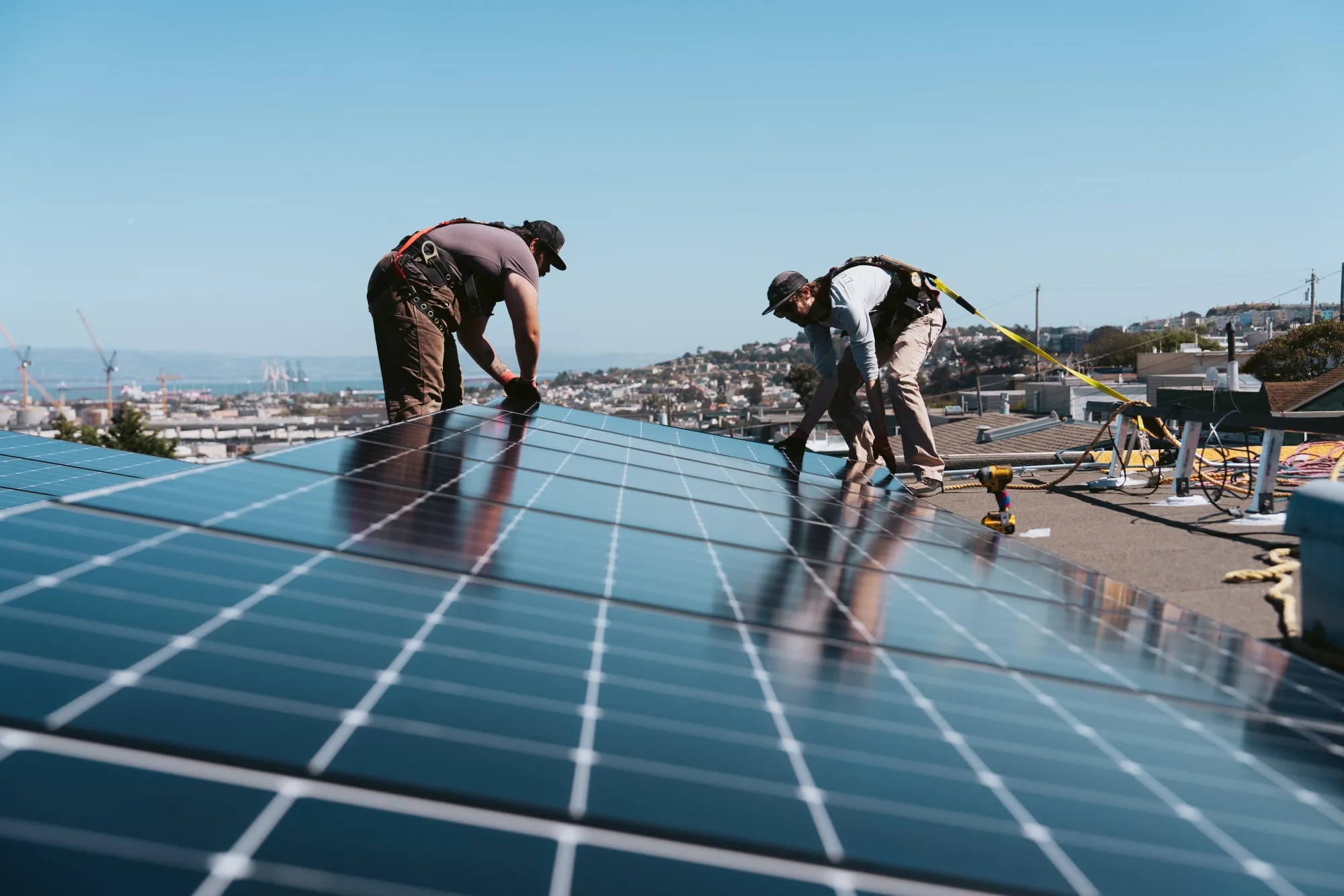 Workers install solar panels on the roof of a home in San Francisco, California.