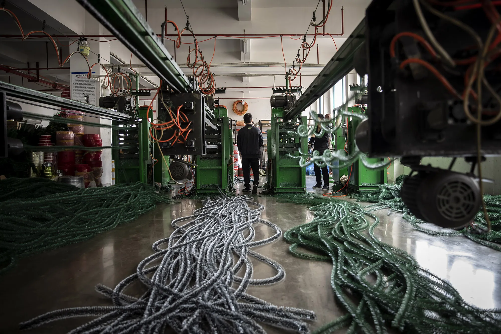 Uncut artificial Christmas tree branches sit on the ground on the production line at a factory in Yiwu, Zhejiang province, China.