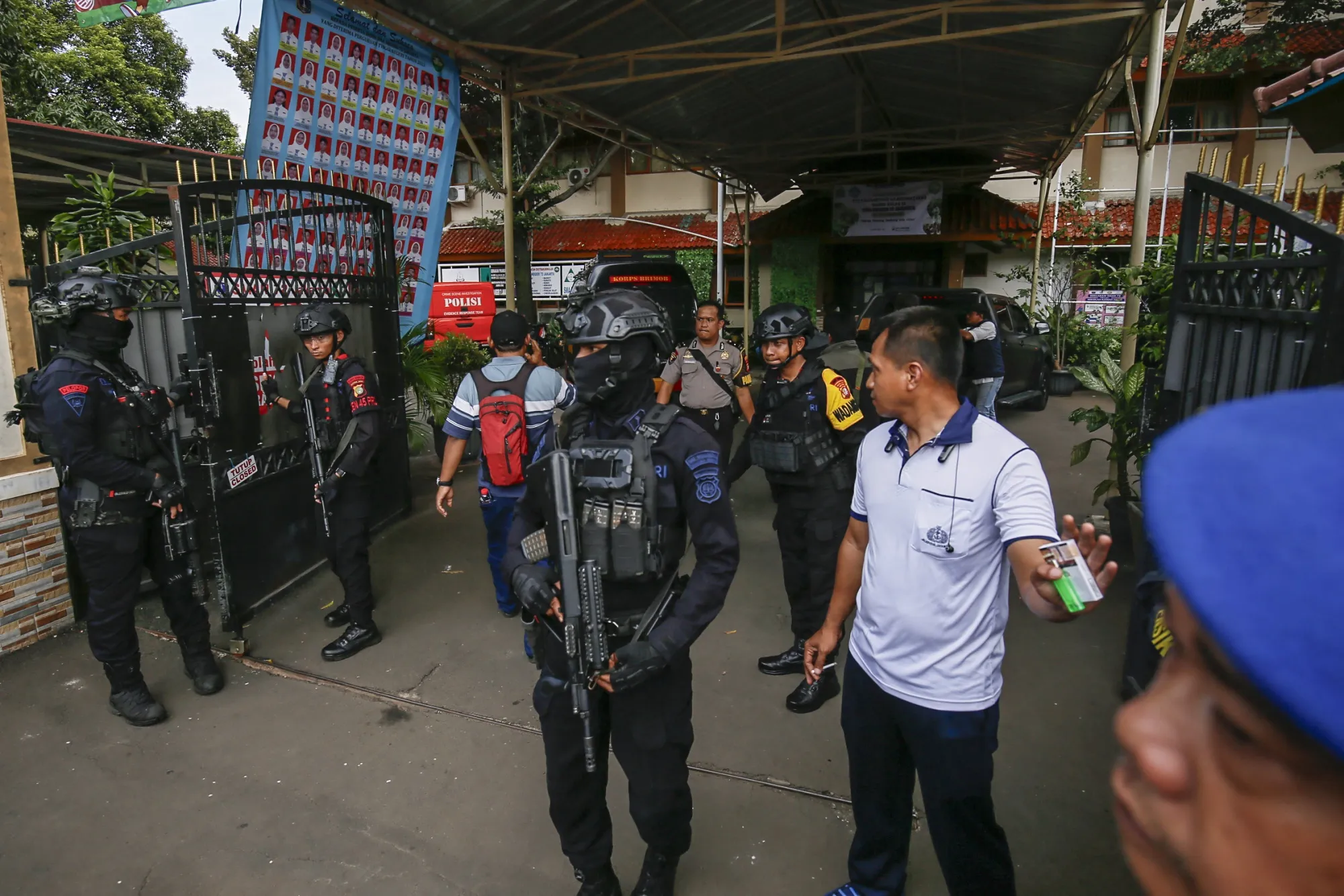 Bomb squad officers stand guard at the entrance of a school in Jakarta on Nov. 7.