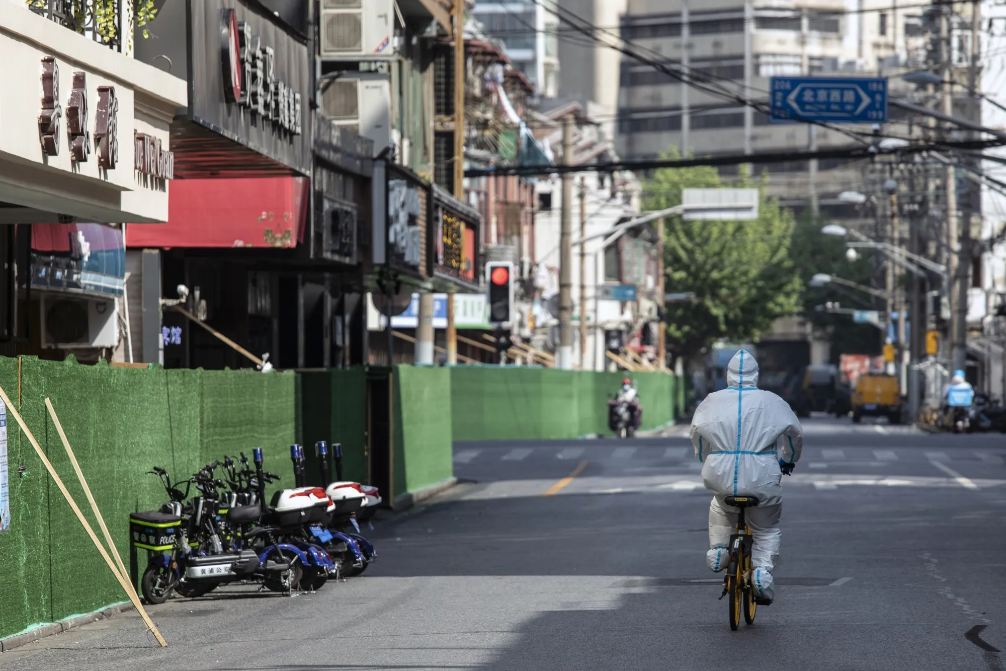 A worker in personal protective equipment&nbsp;rides along a road during a lockdown due to Covid-19 in Shanghai, China, on May 3.