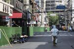 A worker in personal protective equipment rides along a road during a lockdown due to Covid-19 in Shanghai, China, on May 3.