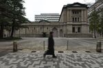 A pedestrian walks past the Bank of Japan (BOJ) headquarters in Tokyo, Japan.