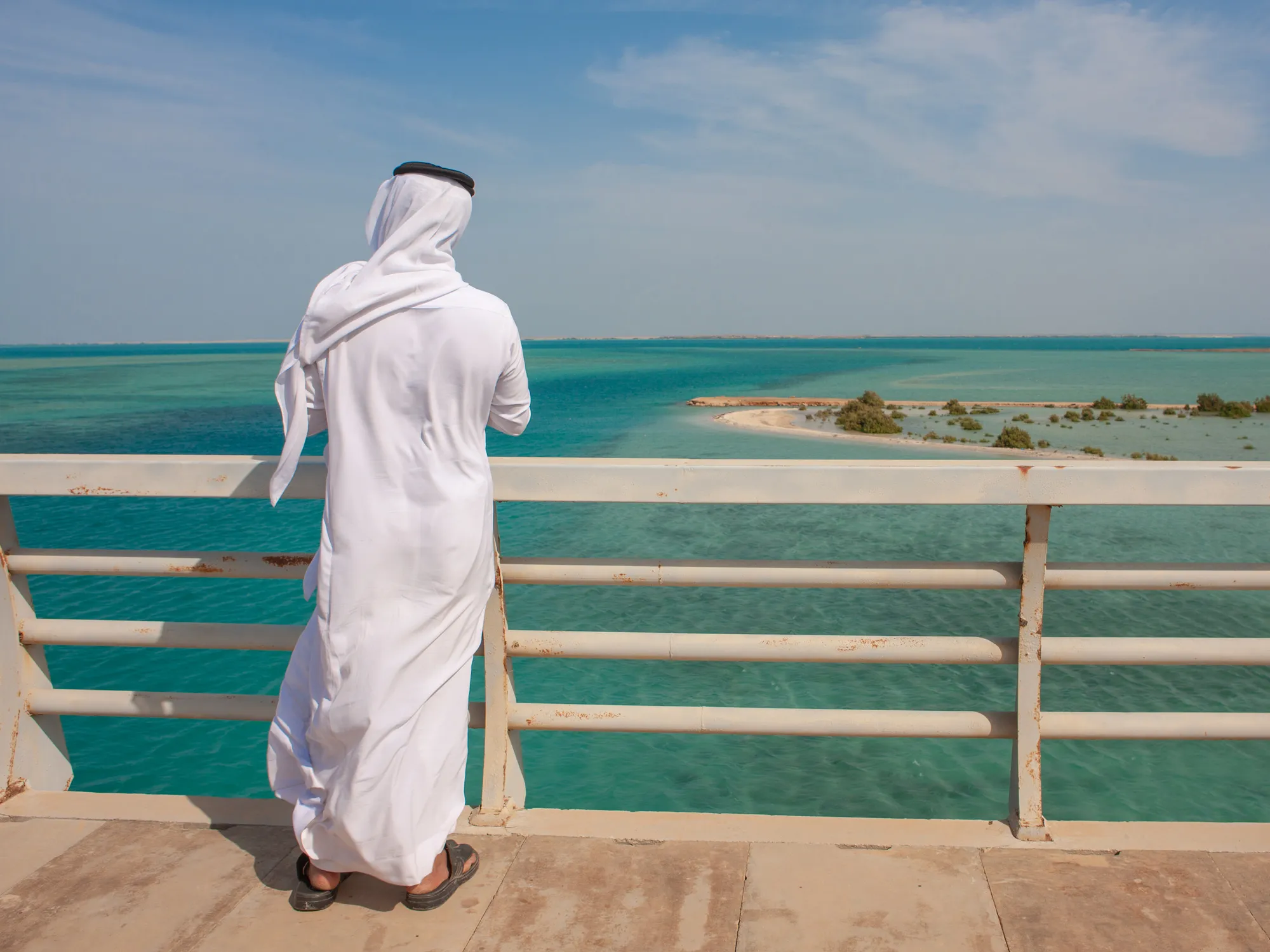 Rear view of a saudi man looking at the red sea from a bridge, Jizan Region, Farasan island, Saudi Arabia