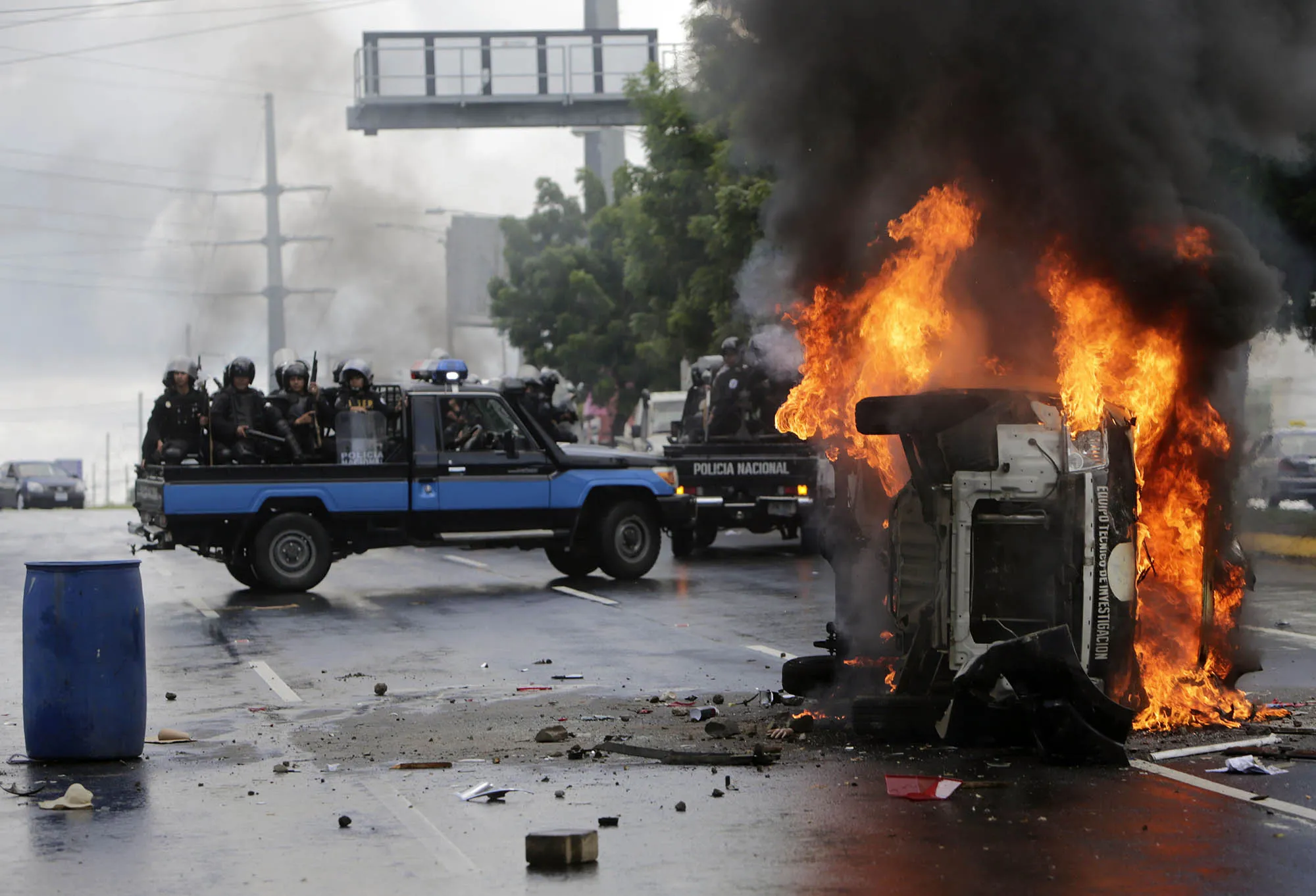 Police officers drive next to an overturned burning police vehicle after an anti-government protest in Managua, on Sept.&nbsp;2, 2018.