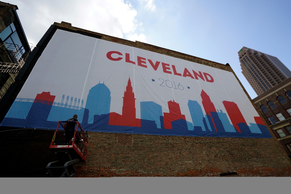 Workers install lighting for a giant banner in downtown Cleveland near the site of the Republican National Convention. 