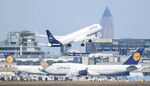 An aircraft of German airline group Lufthansa takes off above others parked on the tarmac at the airport in Frankfurt, Germany.