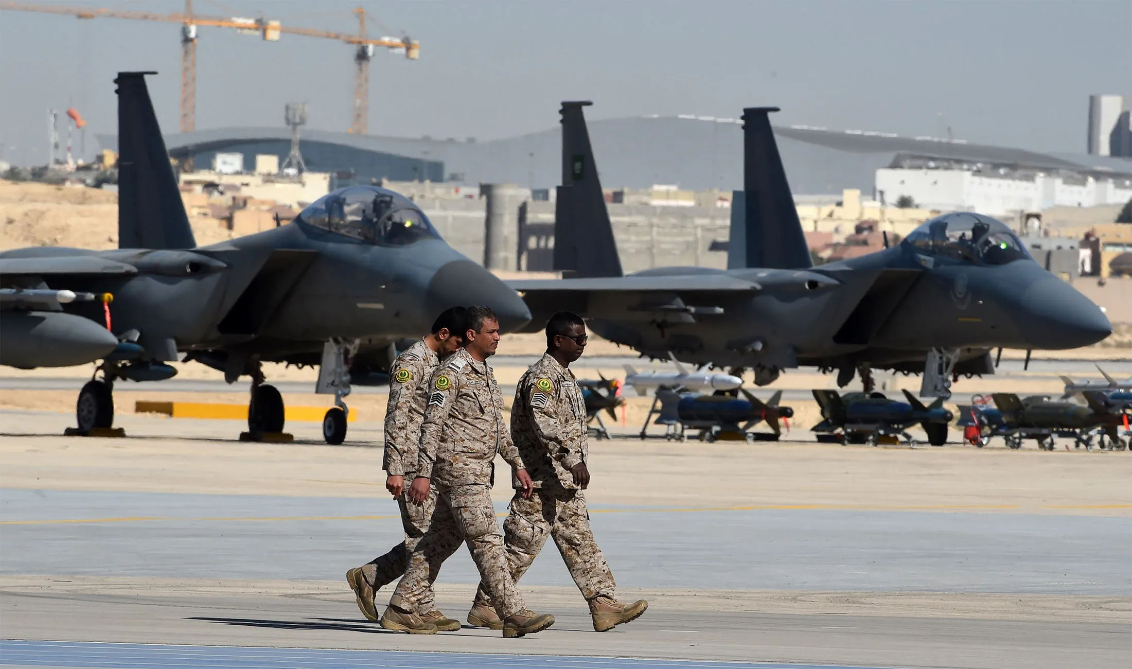 Saudi army officers walk past F-15 fighter jets, GBU bombs and missiles displayed during a ceremony marking the 50th anniversary of the creation of the King Faisal Air Academy at King Salman airbase in Riyadh on January 25, 2017.