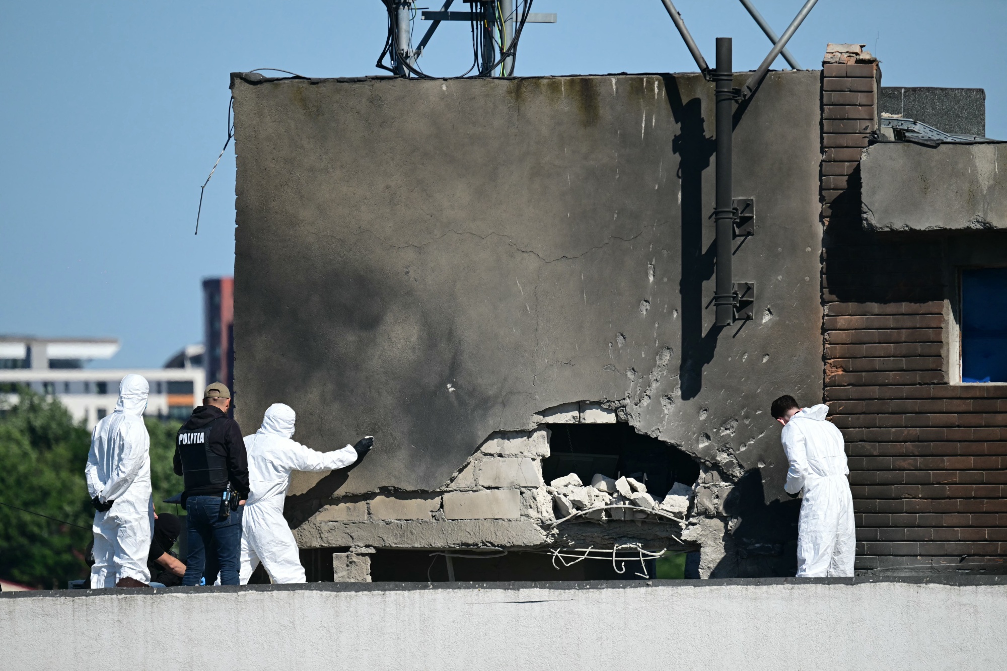 Police and forensic investigators examine the location of impact after a Russian drone struck an apartment building in Galati, Romania, on May 29.