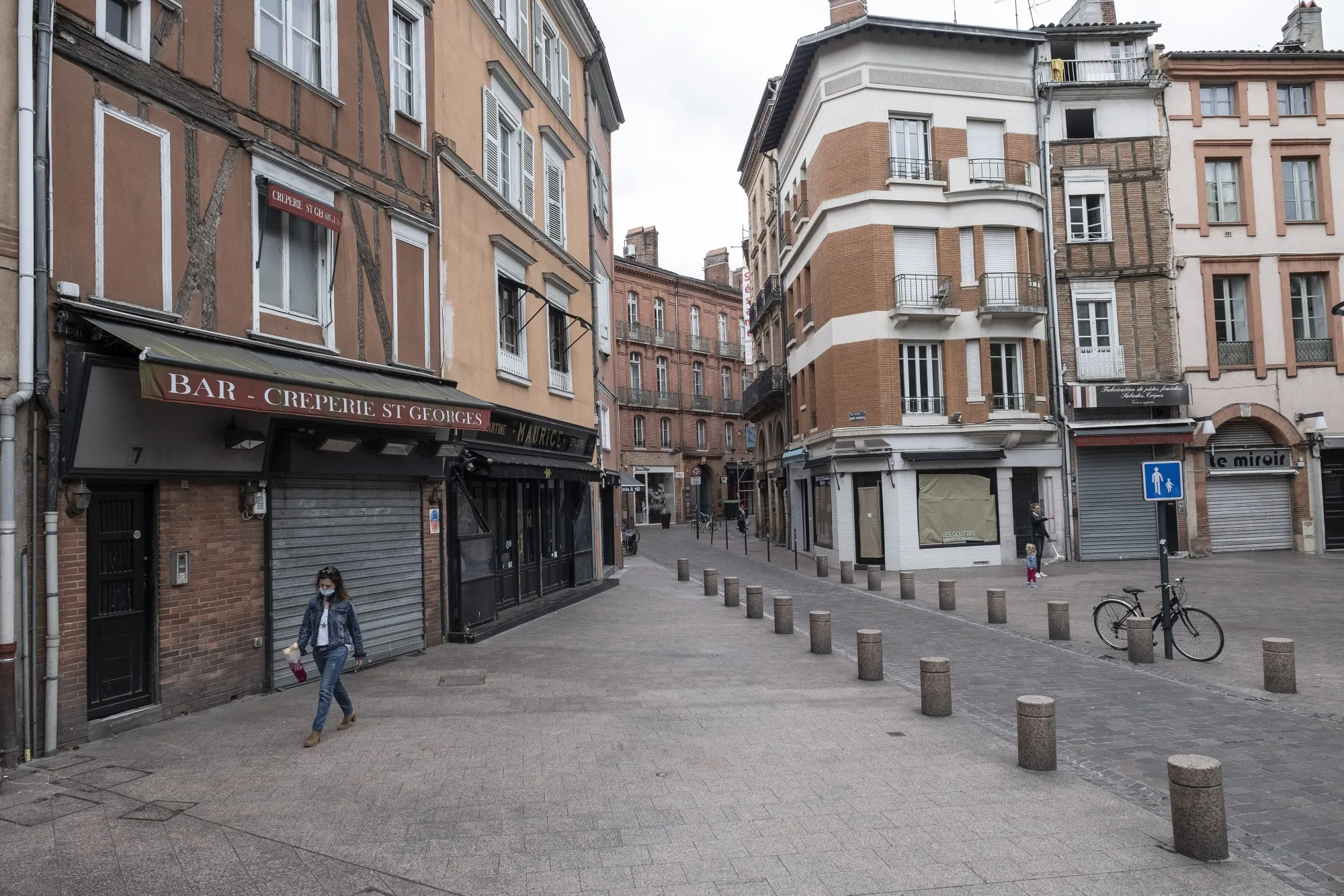 A pedestrian passes shuttered cafes and retail stores during a lockdown in Toulouse, France, on April 27.
