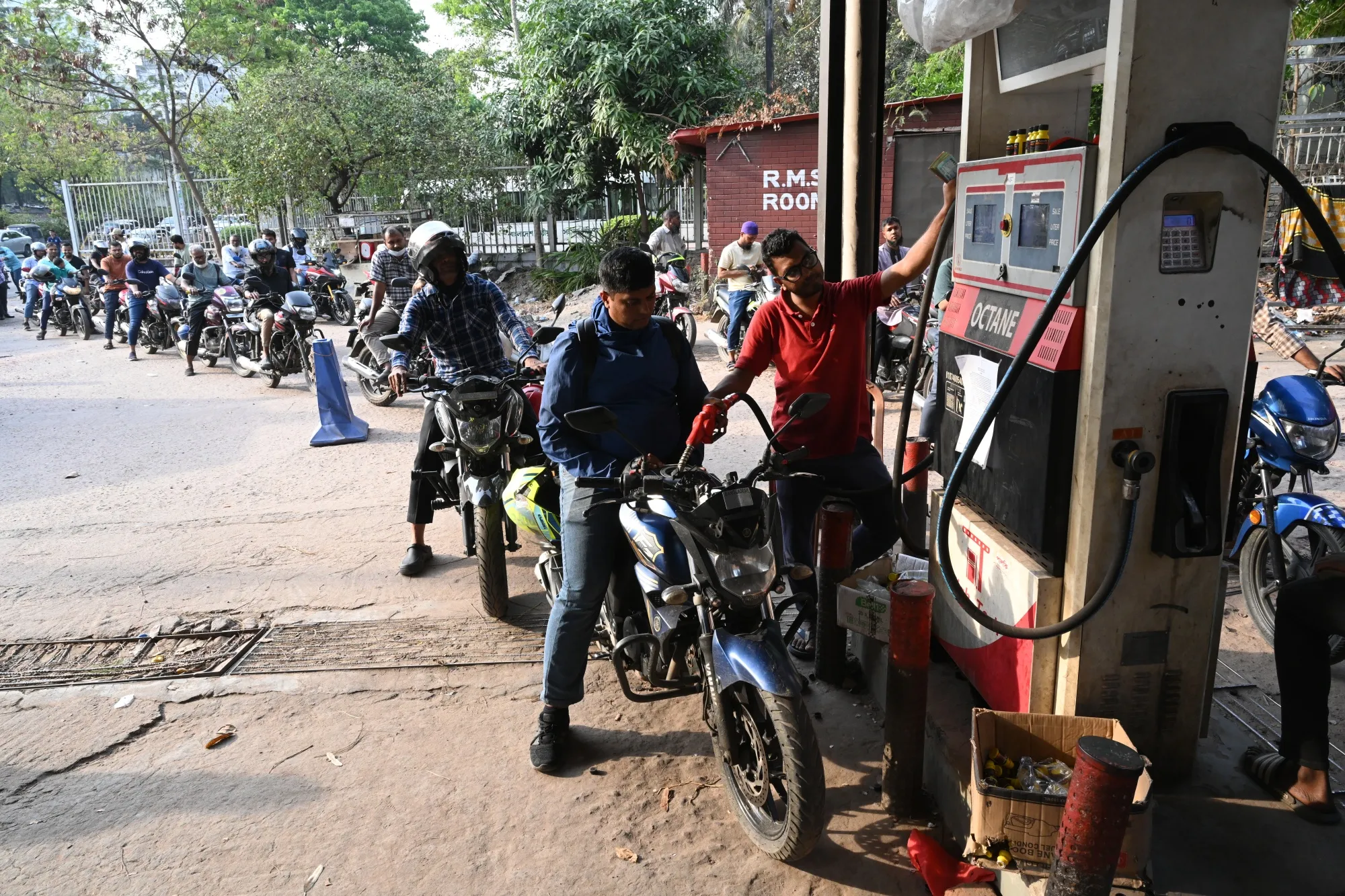People refuel their motorbikes at a fuel station in Dhaka on March 17.