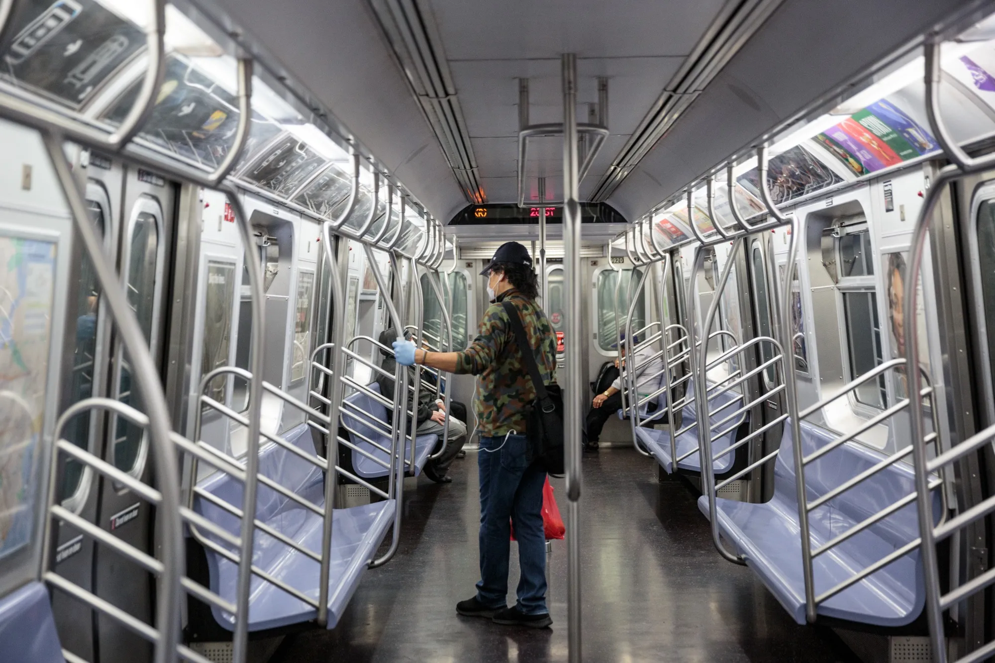 A commuter wears a protective mask and gloves while riding a nearly empty subway in New York, U.S., on&nbsp;June 3.