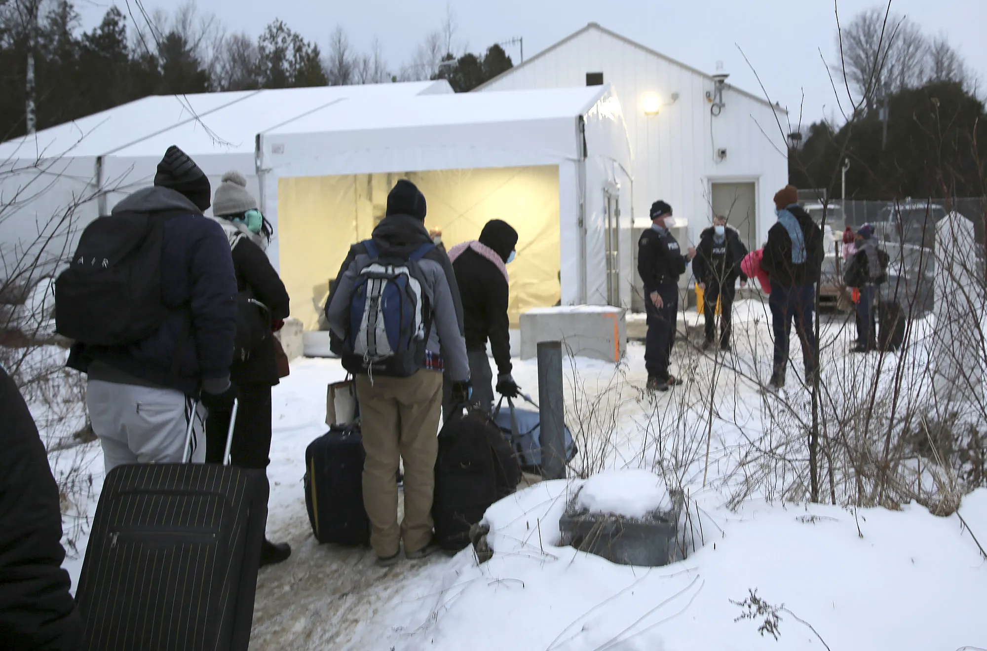 Migrants line up to enter Canada at an informal crossing in Champlain, New York last year.