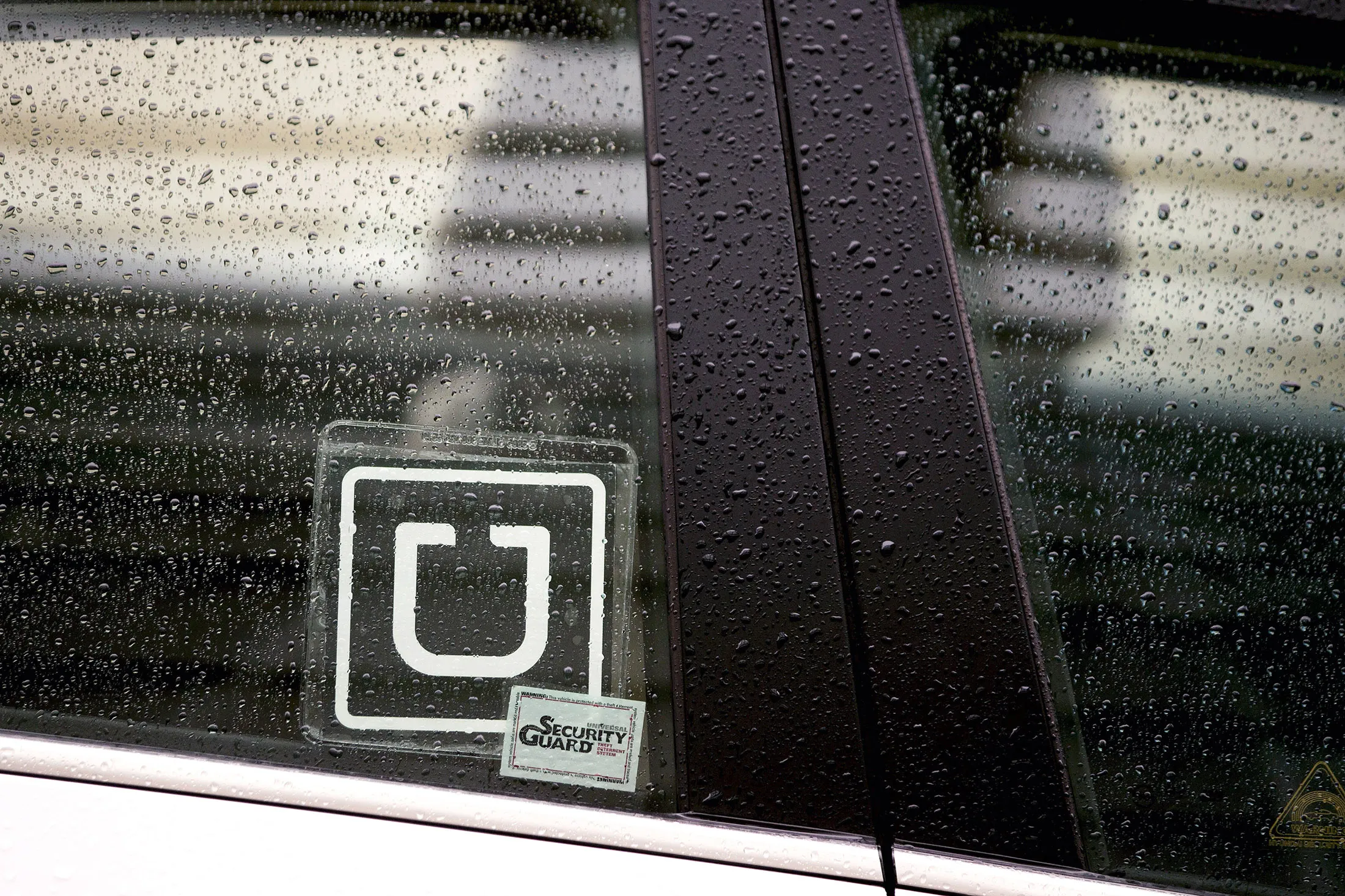 The Uber Technologies Inc. logo is displayed on the window of a vehicle.
