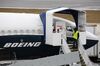 An employee stands next to a Boeing Co. 737 Max 9 plane at the company's manufacturing facility in Renton, Washington.