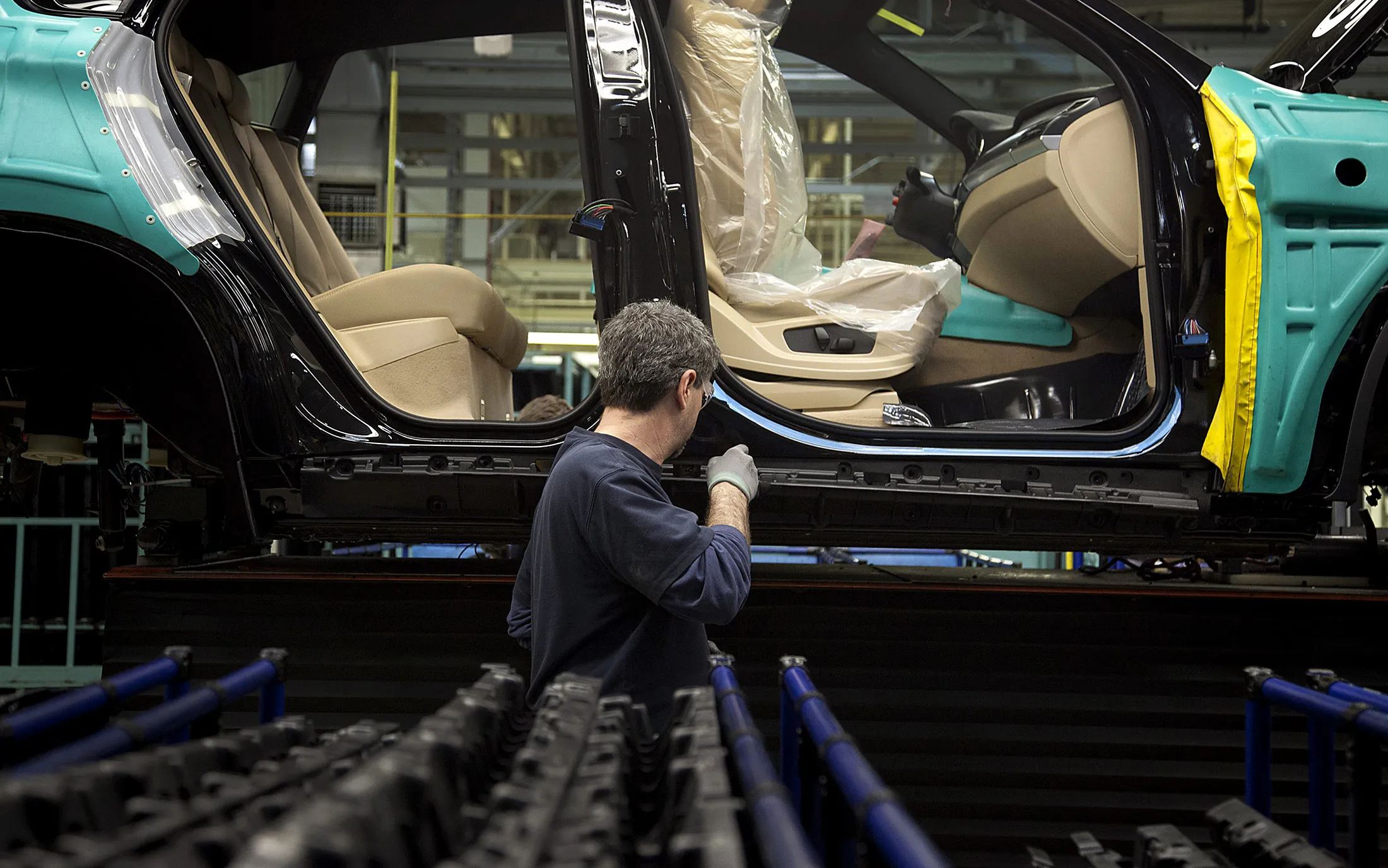 A worker inspects a vehicle on the production line at the BMW manufacturing plant in Spartanburg, South Carolina.
