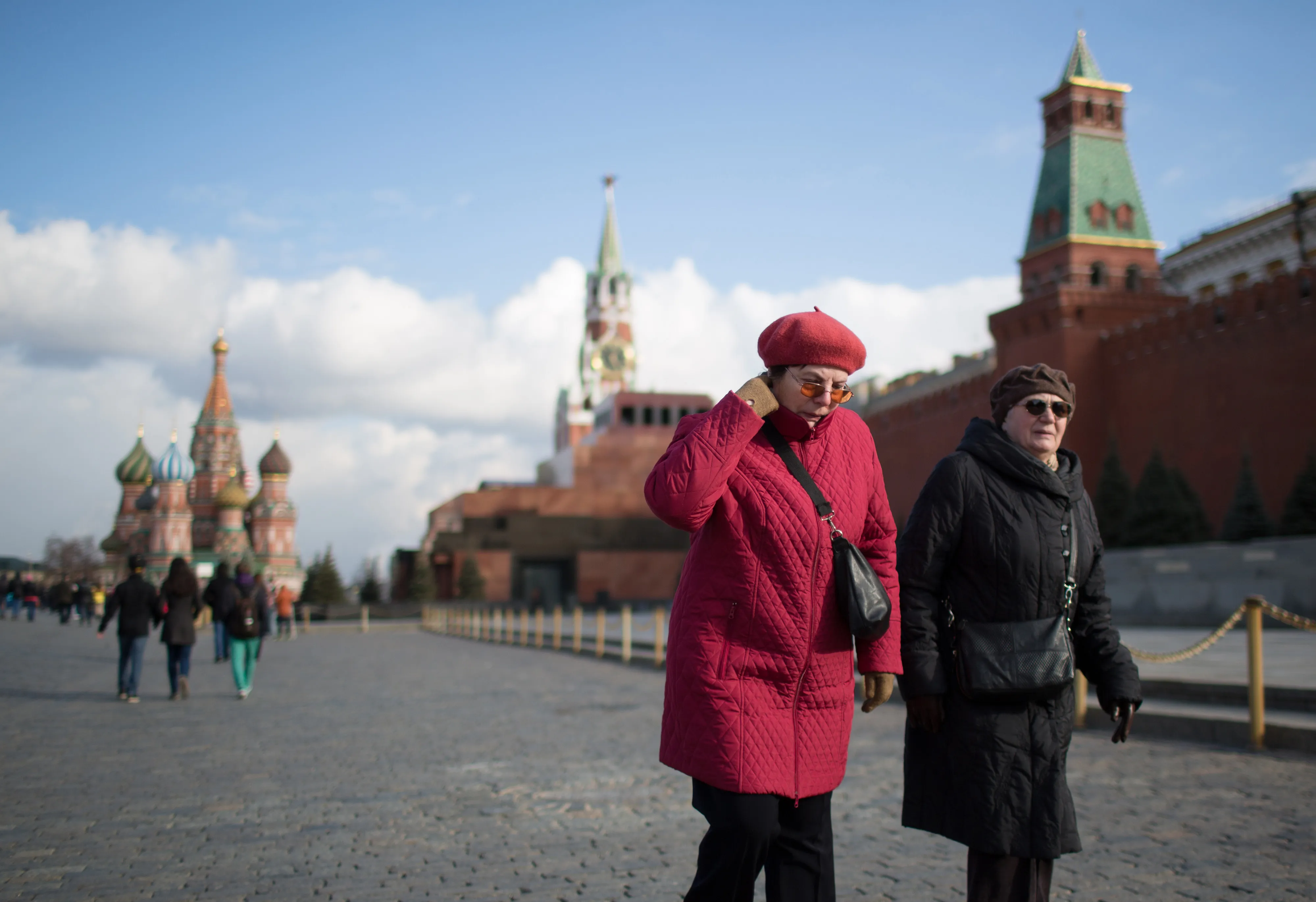 Pensioners walk in Red Square as St. Basil's Cathedral, left, stands beyond in Moscow, Russia, on Saturday, April 18, 2015. Russia will extend a freeze on pension-fund contributions for another year and put off a decision on an overhaul that may result in the confiscation of 3 trillion rubles ($52 billion) of retirement savings, a survey showed.
