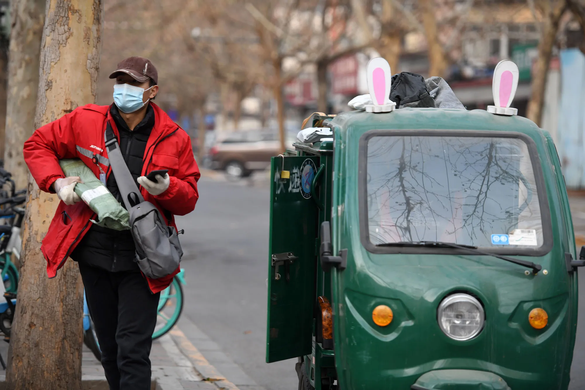 A J&amp;T Express courier prepares packages for residents outside a residential community in Shijiazhuang, China.&nbsp;