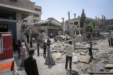 Palestinians inspect damage to a residential building following an Israeli airstrike in Gaza City in June.