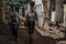 Thais Ferreira, right, walks with a local leader in the Parque das Missoes favela of Rio de Janeiro.
