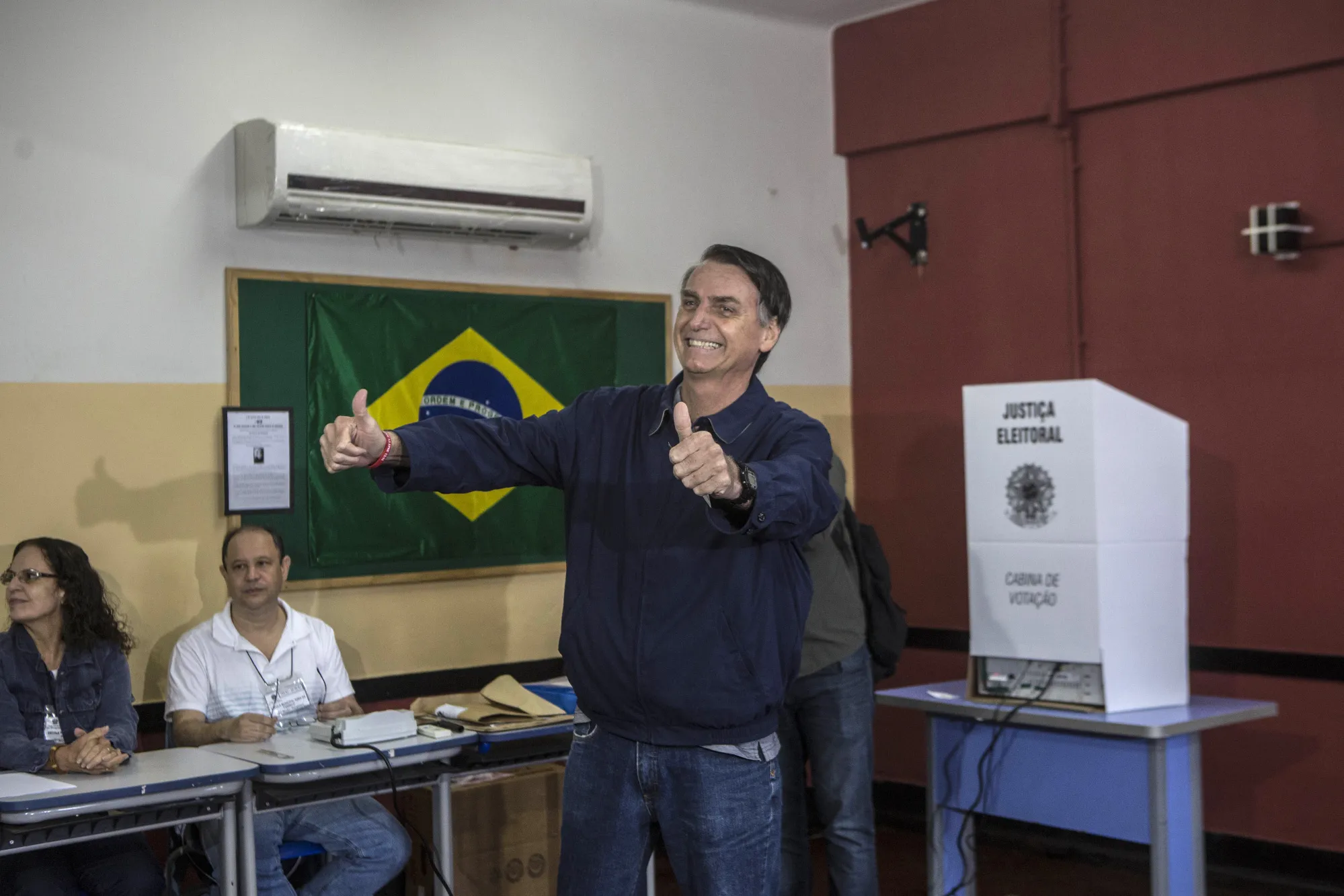 Jair Bolsonaro gives a thumbs up to members of the media before casting his ballot at a polling during the first round of presidential elections in Rio de Janeiro, Brazil on&nbsp;Oct. 7.