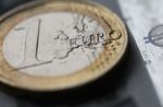 A one euro coin and a euro note is arranged for a photograph in London, U.K., on Tuesday, June 28, 2011. The euro dropped for the first time in seven days versus the greenback after Moody's Investors Service said banks rolling over Greek bonds into new securities may incur impairment charges.