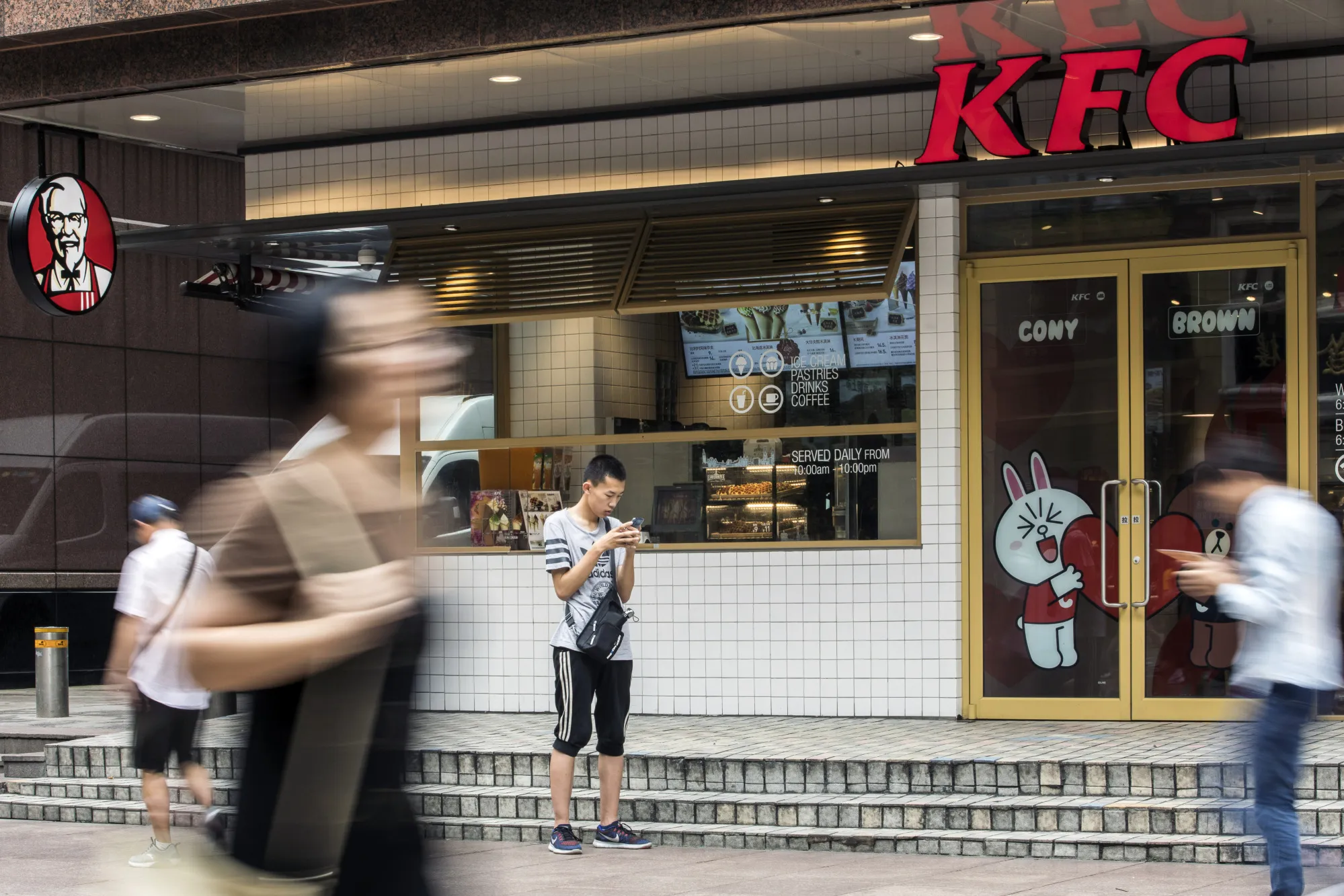 Pedestrians walk past a&nbsp;KFC restaurant in Shanghai.
