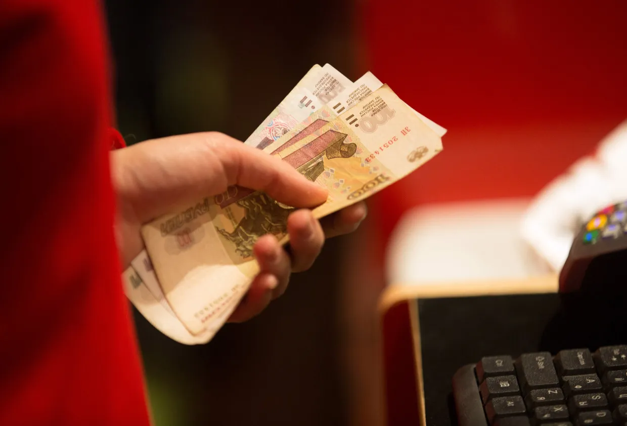 An employee holds ruble banknotes at a&nbsp;store&nbsp;in Moscow.
