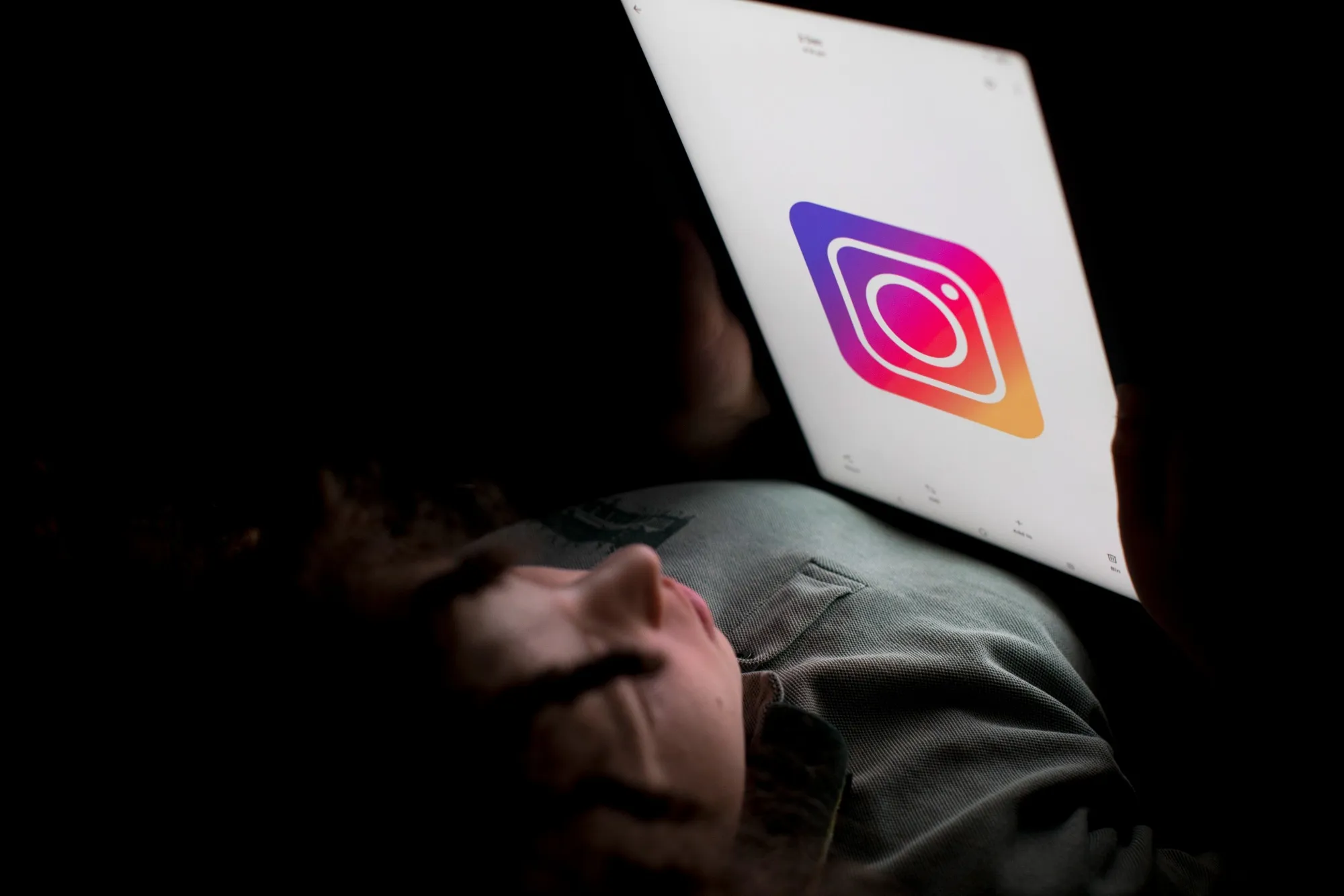A child holds a tablet displaying the Instagram logo in an arranged photograph. California lawmakers have proposed banning social media for those under 16 while a jury in Los Angeles considers the possible harmful effects of the social networks on young people.
