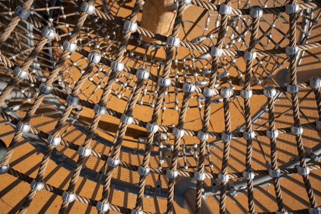 A closeup photo of a climbing structure, made of stainless steel and rope, at the Anna C. Verna Playground.